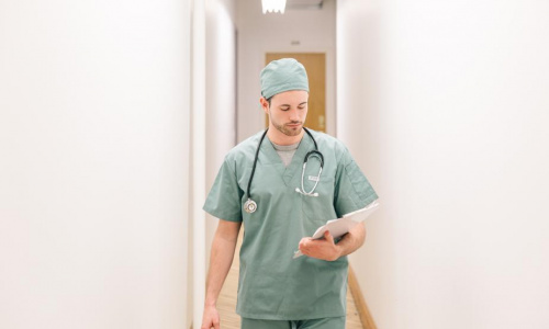 doctor-walking-down-hallway-with-clipboard