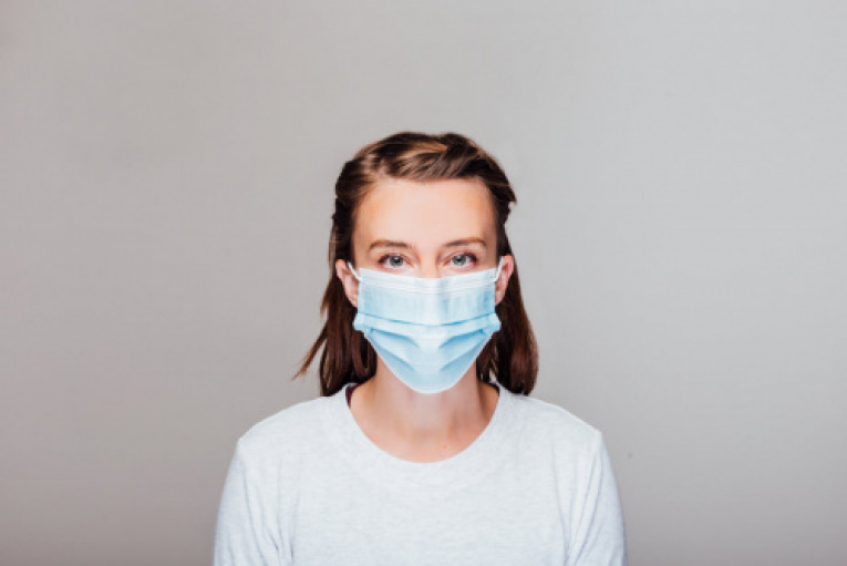 woman-in-grey-sweater-wearing-disposable-face-mask