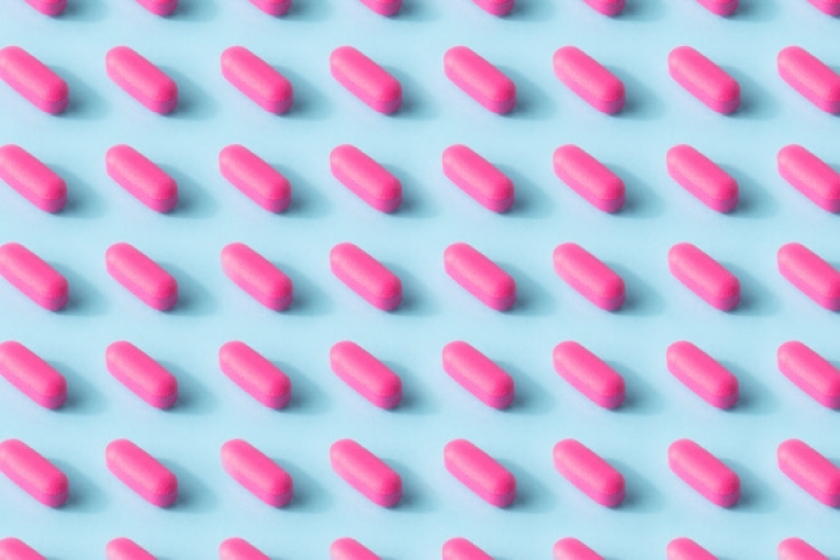 burst-matthew-Henry-pink-pill-pattern-on-a-baby-blue-surface