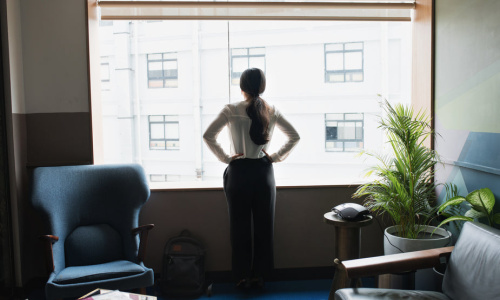 female-executive-looks-out-modern-office-window