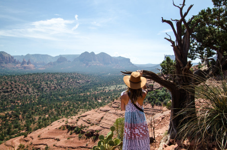 a-woman-by-a-tree-looks-down-over-valley