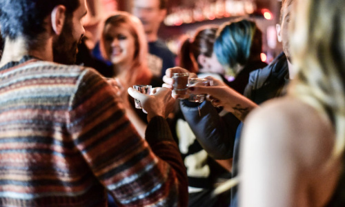 friends-cheers-with-shot-glasses-in-bar