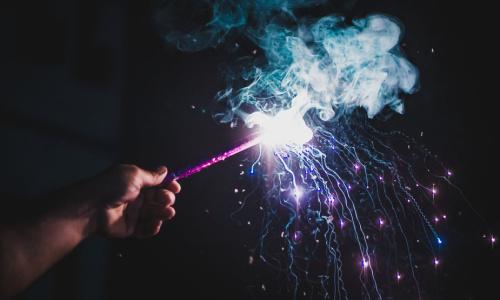 person-holds-lit-firework-with-purple-smoke