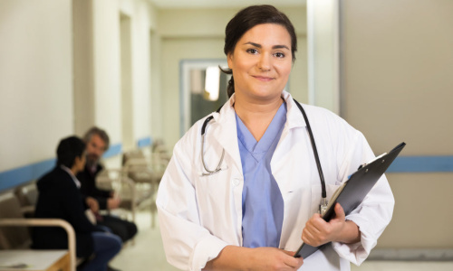 a-doctor-smiles-while-holding-her-clipboard