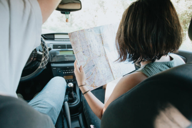 two-people-in-a-car-with-a-large-map-held-up